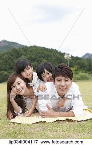 family lying on their stomach posing at camera View Large Photo Image Stock Photo - family lying on their stomach posing at camera. Fotosearch