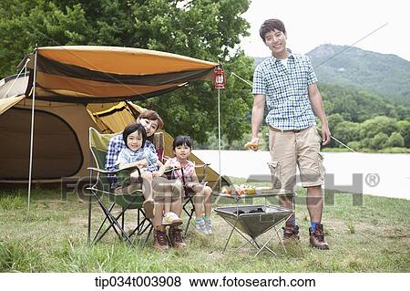 family posing at camera while enjoying their camp View Large Photo Image Stock Photo - family posing at camera while enjoying their camp. Fotosearch