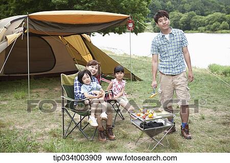 family posing at camera while enjoying their camp View Large Photo Image Stock Photo - family posing at camera while enjoying their camp. Fotosearch