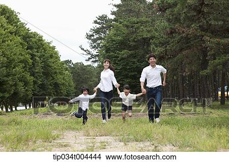 Family running hand in hand on grass View Large Photo Image Picture - Family running hand in hand on grass. Fotosearch