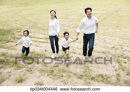 Stock Photograph - Family running on a field . Fotosearch