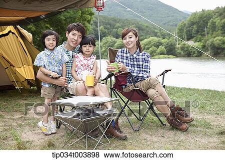 family sitting on camping chairs posing at camera View Large Photo Image Stock Photo - family sitting on camping chairs posing at camera. Fotosearch