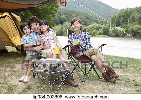 family sitting on camping chairs posing at camera View Large Photo Image Stock Photograph - family sitting on camping chairs posing at camera. Fotosearch