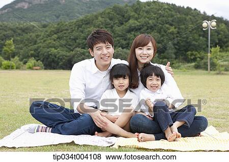 Stock Photo - family wearing jeans posing at camera in picnic. Fotosearch