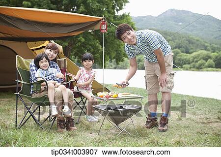 Stock Photo - father posing while grilling . Fotosearch