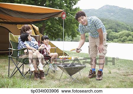 Stock Photograph - father posing while grilling . Fotosearch