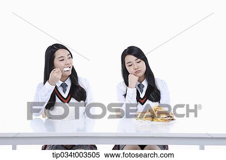female student having a rice while the other identical female student is looking at fast foods View Large Photo Image Stock Photography - female student having a rice while the other identical female student is looking at fast foods. Fotosearch