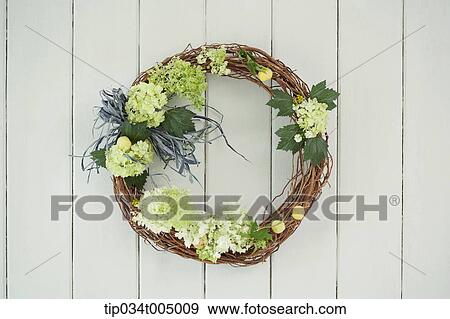 flower wreath hanging on a white wooden wall View Large Photo Image Stock Photo - flower wreath hanging on a white wooden wall. Fotosearch