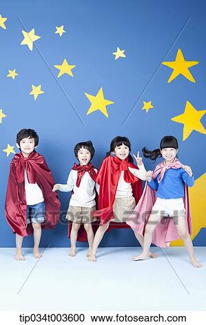 Stock Image - four kids wearing superman capes posing like superman . Fotosearch