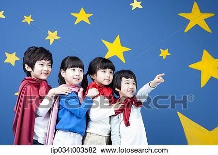 Stock Image - four kids wearing superman capes standing in a line. Fotosearch