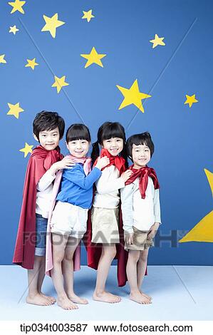 Stock Photo - four kids wearing superman capes standing in a line smiling . Fotosearch