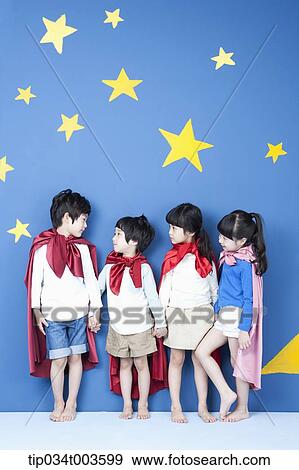 Stock Photo - four kids wearing superman capes standing hands in hands with their backs facing a wall. Fotosearch