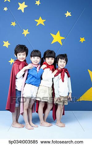 Stock Photography - four kids wearing superman capes standing in a line smiling . Fotosearch