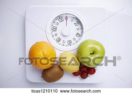 Stock Image - fruits on a weight scale. Fotosearch