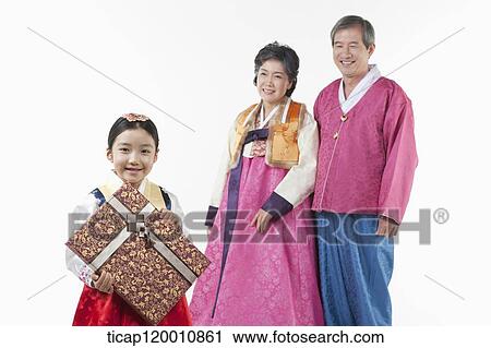 Stock Image - grandparents behind a girl holding present . Fotosearch