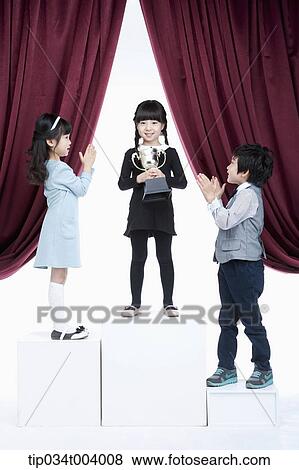 Stock Photo - kids on podium clapping towards the 1st . Fotosearch