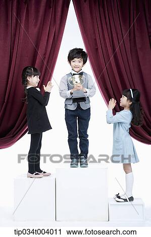 kids on podium clapping towards the 2st in front of red curtains View Large Photo Image Stock Image - kids on podium clapping towards the 2st in front of red curtains. Fotosearch