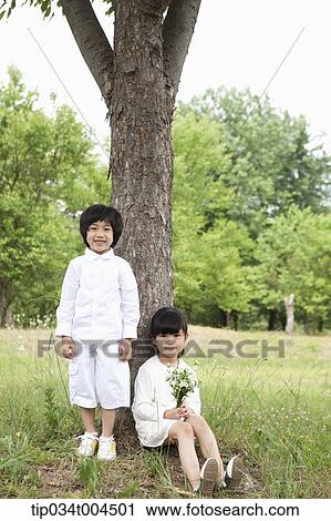kids standing and sitting under a tree View Large Photo Image Stock Image - kids standing and sitting under a tree. Fotosearch