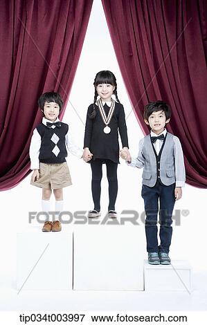 Stock Photo - kids standing on podium in front of red curtains. Fotosearch