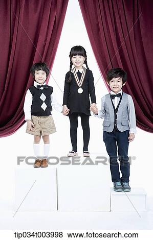 Stock Photo - kids standing on podium with medals in front of red curtains. Fotosearch