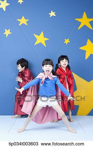 Stock Image - kids wearing superman capes posing . Fotosearch