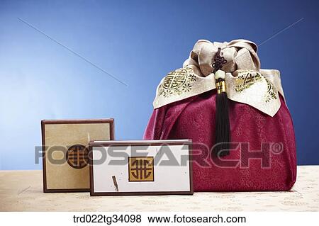 Stock Photo - Korean traditional boxes in front of a package in a red Korean traditional wrap . Fotosearch