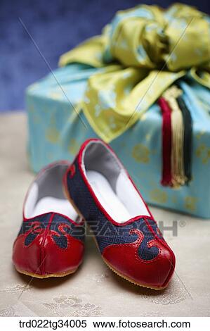 Stock Photography - Korean traditional shoes next to a package wrapped in traditional wrap . Fotosearch