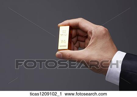 man holding a gold bar View Large Photo Image Stock Image - man holding a gold bar. Fotosearch