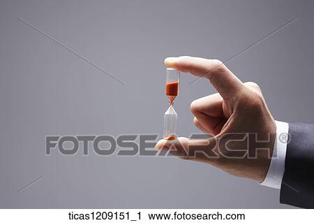 Stock Image - man holding a sandglass. Fotosearch