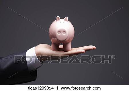 man holding piggy bank in his hand View Large Photo Image Stock Image - man holding piggy bank in his hand. Fotosearch