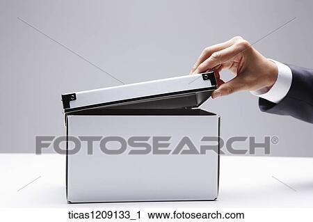 Stock Image - man opening the box. Fotosearch
