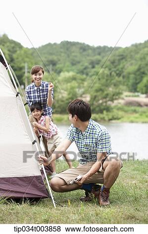 mother and daughter talking to father building a tent View Large Photo Image Stock Photo - mother and daughter talking to father building a tent. Fotosearch