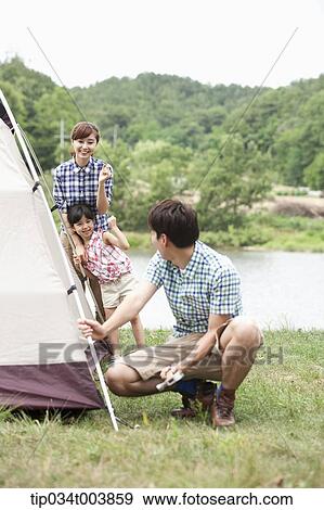 mother and daughter talking to father building a tent View Large Photo Image Stock Photo - mother and daughter talking to father building a tent. Fotosearch