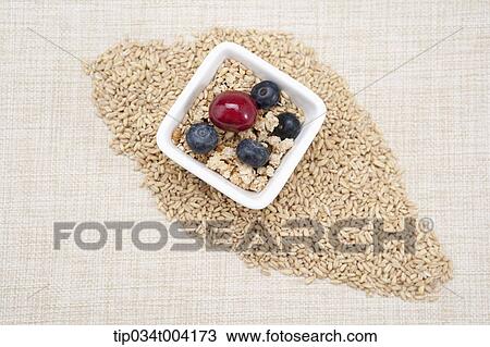 Stock Image - nuts, blueberries and a cheery in a small bowl with seeds under a bowl . Fotosearch