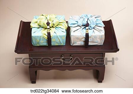 Picture - packages in Korean traditional wraps placed on a traditional table . Fotosearch