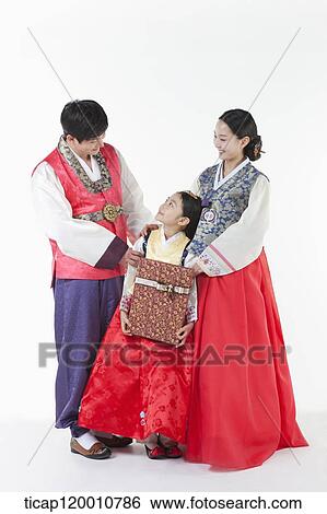 parents in Hanbok standing behind a daughter holding a present View Large Photo Image Stock Photograph - parents in Hanbok standing behind a daughter holding a present . Fotosearch