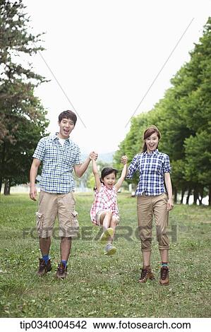 Stock Image - parents lifting a daughter up . Fotosearch