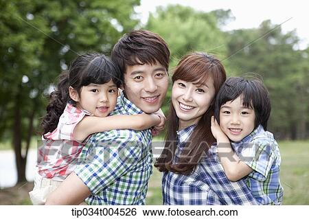 Stock Photograph - parents posing with kids in their back . Fotosearch