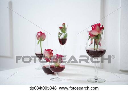 Stock Photo - red wine and flowers in wine glasses. Fotosearch