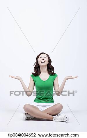 Stock Image - Surprised woman in green T-shirt with hand gesture. Fotosearch