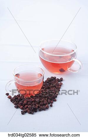 Stock Photography - two cups of omija tea and fruit of Maximowiczia typica. Fotosearch