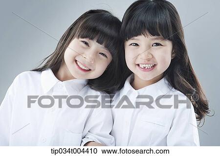 Stock Image - two female kids smiling together. Fotosearch