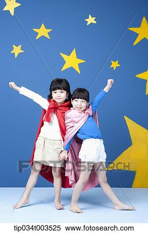 Stock Photography - two girls wearing superman capes posing like superman. Fotosearch