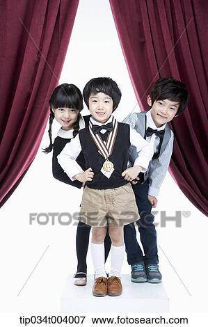 two kids posing behind a boy with a medal View Large Photo Image Stock Photo - two kids posing behind a boy with a medal . Fotosearch