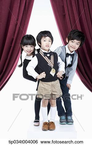 two kids posing behind a boy with a medal View Large Photo Image Stock Photograph - two kids posing behind a boy with a medal . Fotosearch