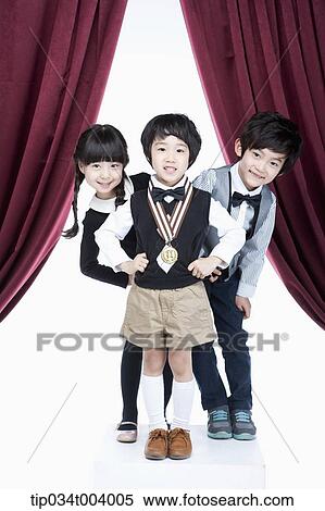 Stock Photography - two kids posing behind a boy with a medal . Fotosearch