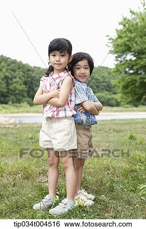 two kids posing with their back against each other View Large Photo Image Stock Photograph - two kids posing with their back against each other. Fotosearch