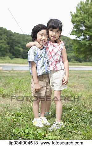 two kids standing with arms around each other View Large Photo Image Stock Photo - two kids standing with arms around each other. Fotosearch