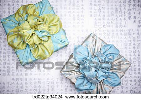 Picture - two packages wrapped in a traditional wrap with big ribbons. Fotosearch