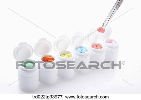 Stock Photo - white drug bottles filled up with different colours of medicine tablets . Fotosearch